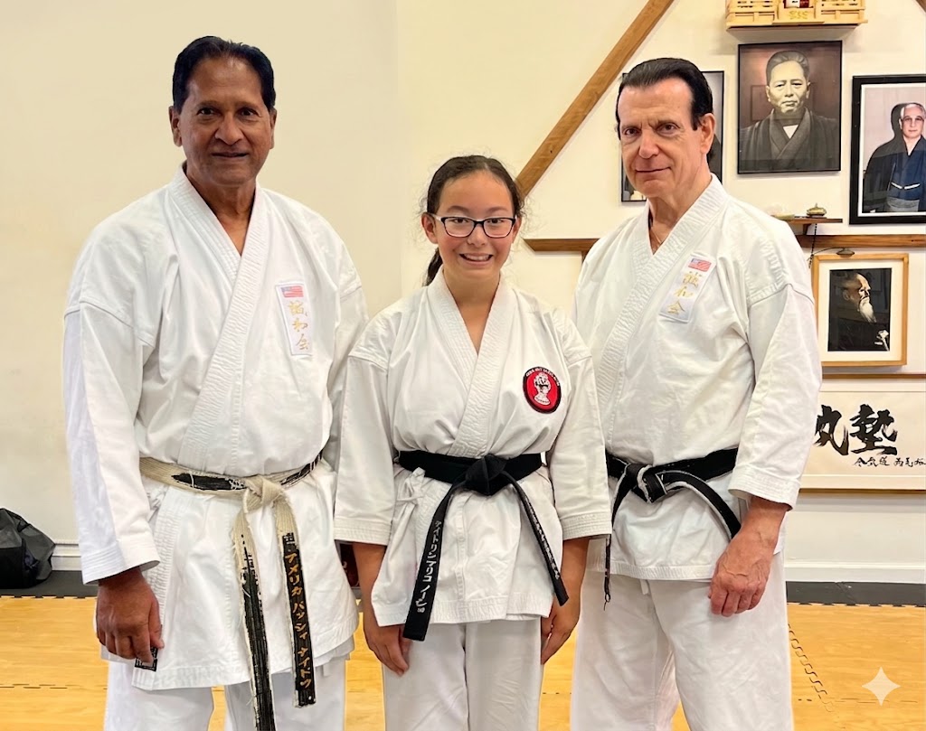 Shihan Vassie Naidoo and dojo instructors standing proudly alongside a youth K.I.C.K. Crew student on the martial arts training floor.