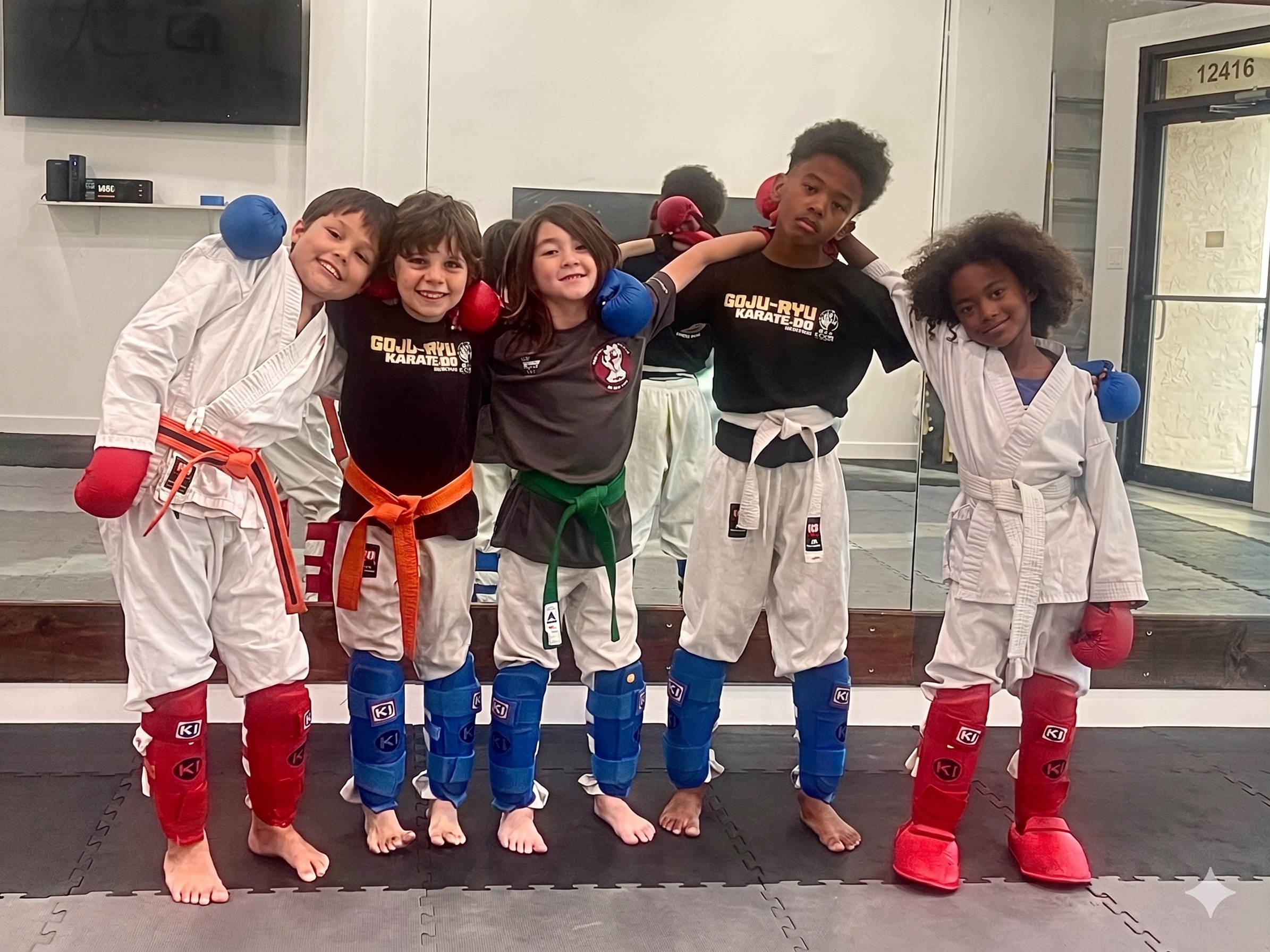 Youth K.I.C.K. Crew students practicing traditional martial arts block and stance techniques together on the dojo floor at Karate of LA.